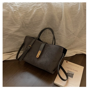 Close-up of retro dark grey matte tote bag featuring a polished gold bar metal lock detail