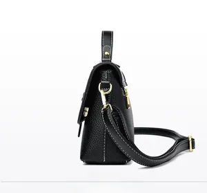 Detailed side view of black lychee leather handbag with elegant white contrast stitching