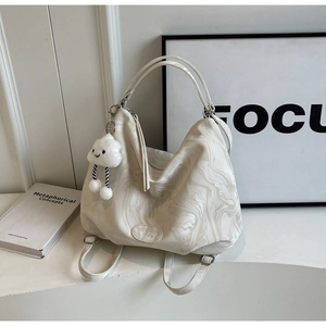 Close-up of cream marble textured leather tote bag with cloud charm and branding detail
