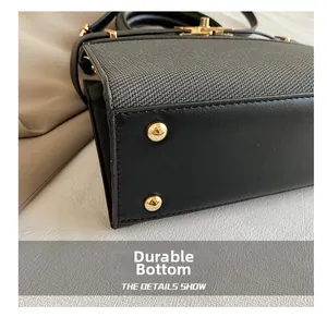 Detail view of wear-resistant bag bottom with gold metal feet and woven fabric
