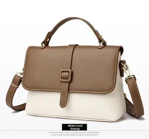 Detail view of khaki and white contrast leather messenger bag with gold hardware