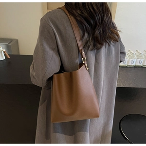 Detail of brown litchi pattern leather tote bag with adjustable strap and gold hardware