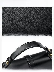 Close-up of black lychee grain leather handbag with white stitching and gold metal rivets