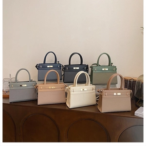 Collection of textured leather handbags in seven colors featuring metal twist-lock hardware