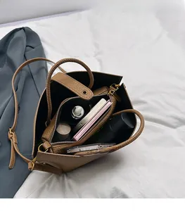 Detailed view of spacious brown leather tote bag interior with multiple compartments