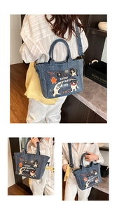 Detail of cartoon denim tote showing sturdy handles and adjustable canvas shoulder strap