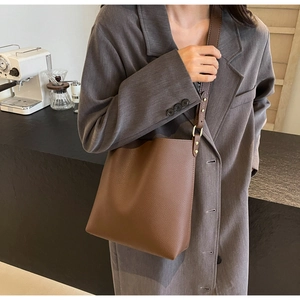 Brown lychee texture leather bucket bag shown on model for a chic commute style