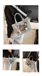 Detail showing cartoon cat denim tote bag worn as a shoulder and crossbody bag