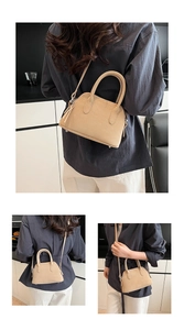 Macro view of beige shell bag featuring pebble leather texture and silver-tone hardware