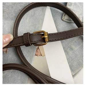 Macro detail of dark brown leather strap with vintage gold square buckle and fine stitching