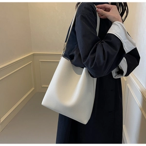 Detailed view of white lychee leather texture and minimalist shoulder strap design