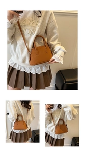 Detail of camel brown crossbody bag with lychee grain leather and adjustable shoulder strap