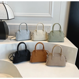 Collection of six small shell-shaped handbags in various colors with tassel zippers