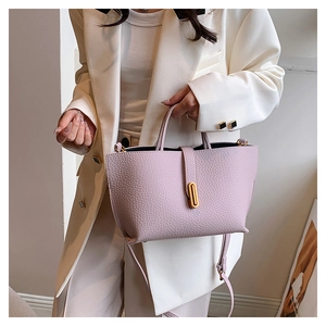 Detail of light purple tote bag with lychee texture and gold oval rotating lock