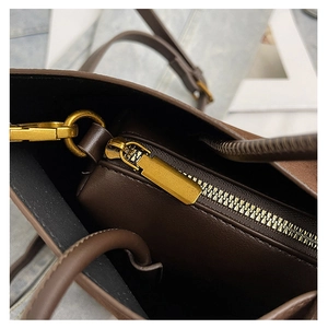 Close-up of the brown leather handbag interior with black lining and gold zipper detail