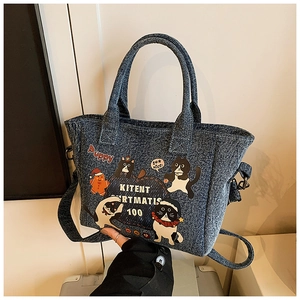 Detail of blue denim tote bag featuring cartoon cat and gingerbread man illustrations