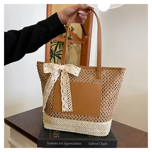 Close-up of handmade woven tote bag with lace bow decoration and leather handles