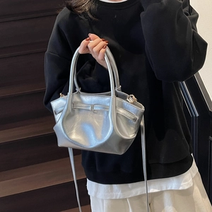 Détail d'un sac cabas plissé argenté métallisé avec nœud décoratif et fine bandoulière
