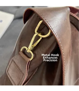 Detail einer dunkelbraunen Ledertasche mit goldenem Metallhaken und feiner Steppnaht