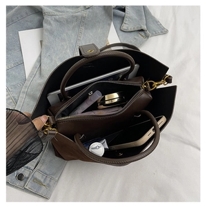 Interior view of brown leather tote showing large capacity with inner bag and essentials