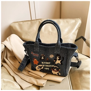 Detail of cartoon patchwork patterns and wavy edge on dark blue denim tote bag