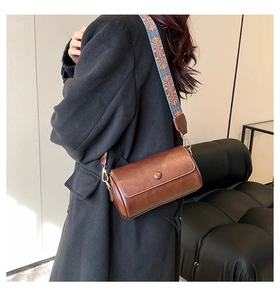 Brown retro cylindrical bag featuring a vintage ethnic pattern wide shoulder strap