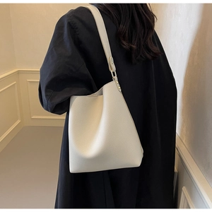 Detailed view of the white lychee grain leather bucket bag showing its textured finish