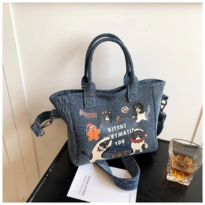 Detail of cartoon denim tote bag with cat prints and adjustable shoulder strap hooks