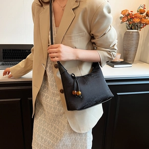 Elegant black embroidered crescent underarm bag with amber beads and a chic retro style