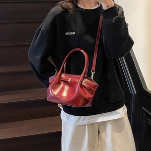 Détail du sac cabas plissé bordeaux avec boucle argentée et texture cuir brillant