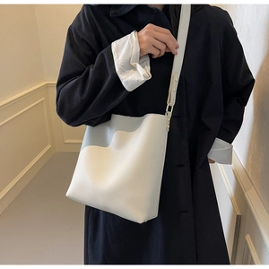 Detailed view of cream lychee-textured leather tote bag with adjustable shoulder strap