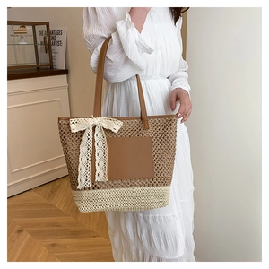 Détail du sac cabas en paille tissée avec nœud en dentelle blanche et touches de cuir