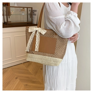 Detail of hand-woven tote bag with lace bow and leather patch in soft indoor setting