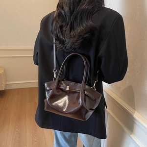 Détail du cabas vintage en cuir marron café avec boucle dorée et bandoulière élégante