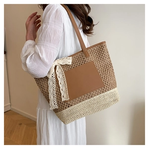 Détail de sac cabas en paille tissée avec nœud en dentelle blanche et patch en cuir
