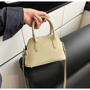 Detail view of the pale green lychee texture small square bag with metal bottom studs
