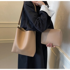 Detail view of camel litchi grain tote and matching zippered pouch with gold accents