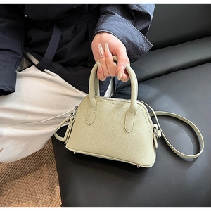 Detail view of the light green crossbody bag with lychee texture and silver hardware