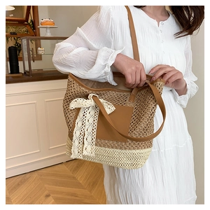 Détail d'un sac cabas en paille avec nœud en dentelle blanche et poignée en cuir brun