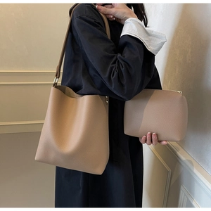 Detail of beige lychee textured bucket tote bag and matching inner zipper pouch set