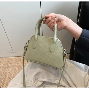 Detail of light green crossbody bag with lychee texture and silver hardware