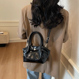 Détails du sac cabas en cuir verni noir avec boucle métallique et texture plissée chic