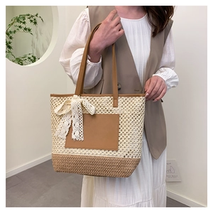 Détail du sac cabas en paille tissé avec accents en cuir et un nœud en dentelle blanche