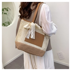 Détail du sac cabas en paille tissé avec panneaux contrastés et grand nœud décoratif en dentelle