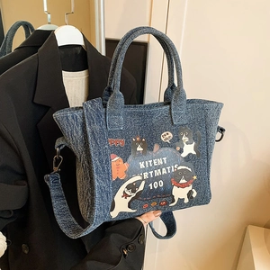 Deep blue denim tote bag with cartoon cat prints and adjustable shoulder strap for women