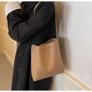 Detail of camel lychee grain PU leather tote bag with side gold rivet accents