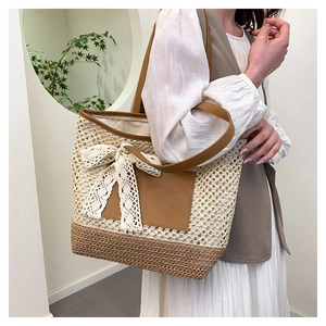 Détail du sac cabas en paille tissé main avec nœud en dentelle et anses en cuir