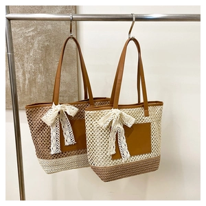 Détail de sacs cabas en paille tissée avec nœuds en dentelle et anses en cuir
