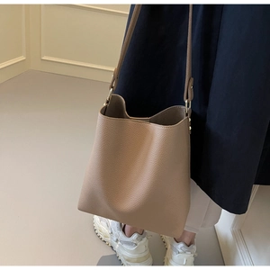 Close-up of camel lychee pattern leather tote bag with adjustable golden buckle