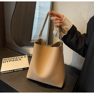 Detail of light brown lychee grain leather tote bag with slender shoulder strap